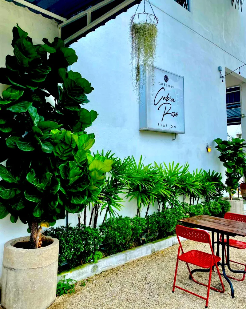 Papan tanda Cabin Rose Station di laman kafe